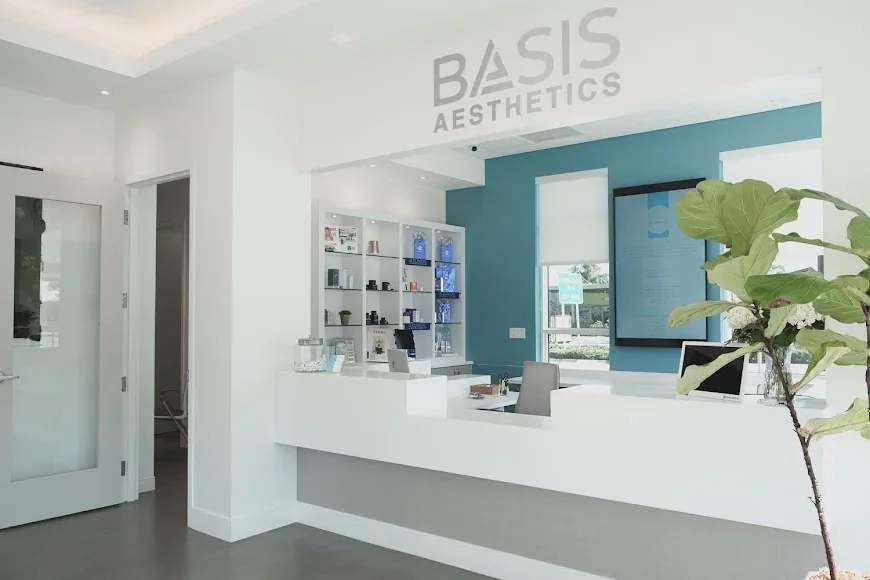 Empty Basis Aesthetics reception with white counter, turquoise wall and display shelves.