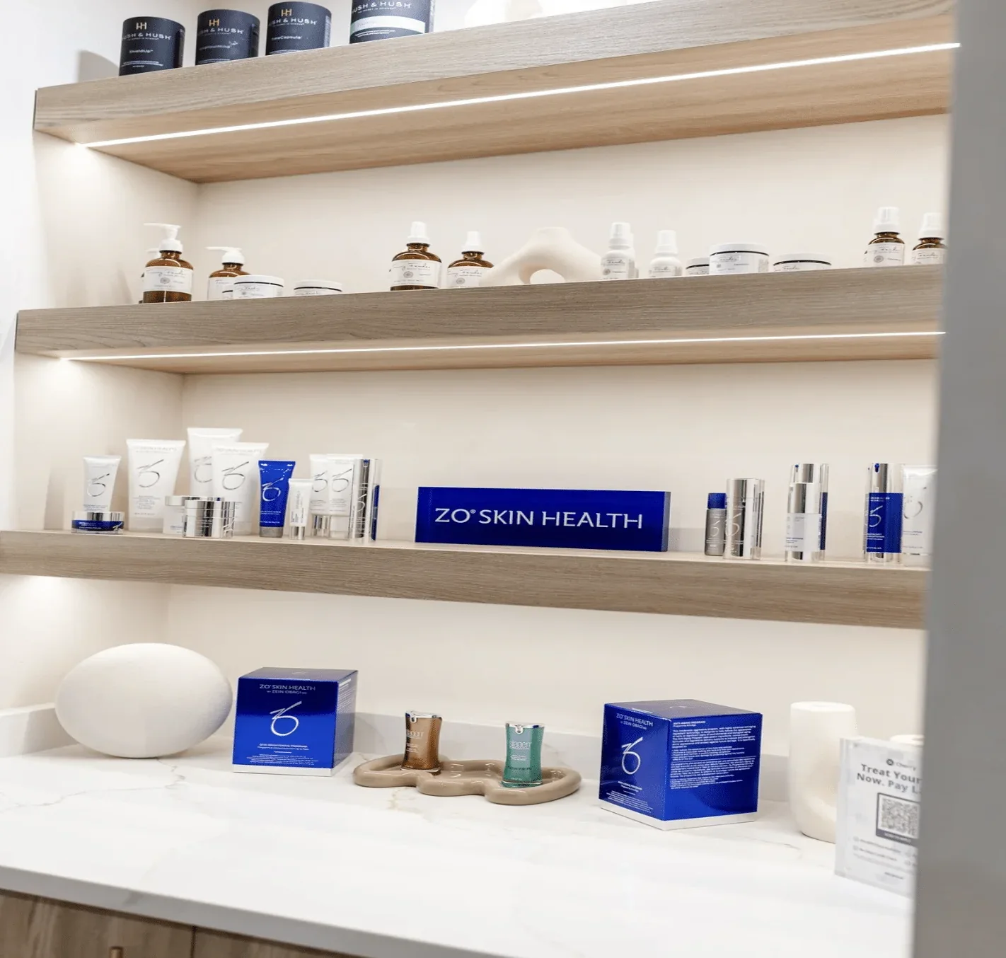 Illuminated wooden shelves with skincare bottles at ReSpa Palm Beach.
