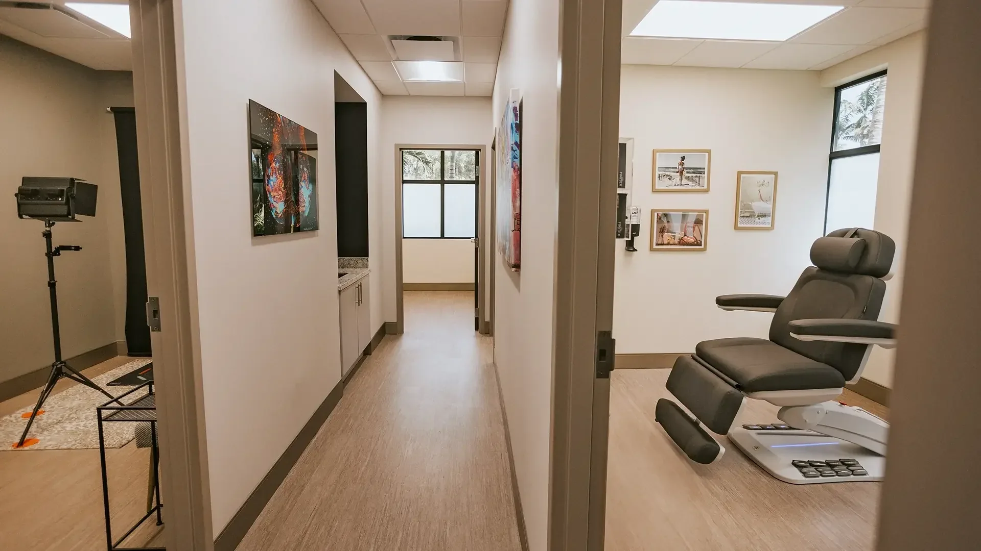 Hallway opening into an empty treatment room with a dark reclining chair.