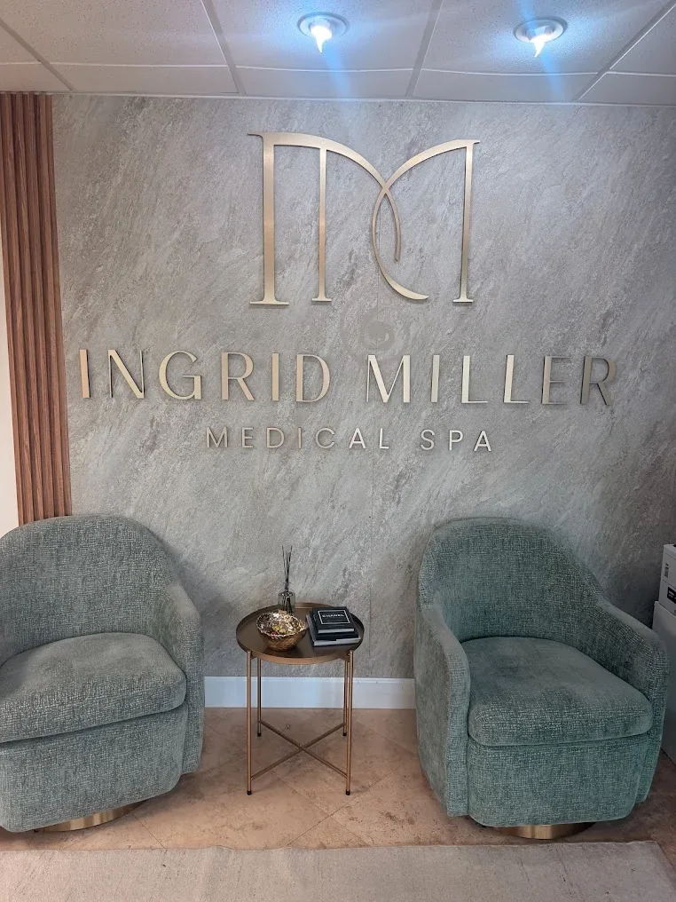 Two green armchairs beneath Ingrid Miller Medical Spa wall lettering.