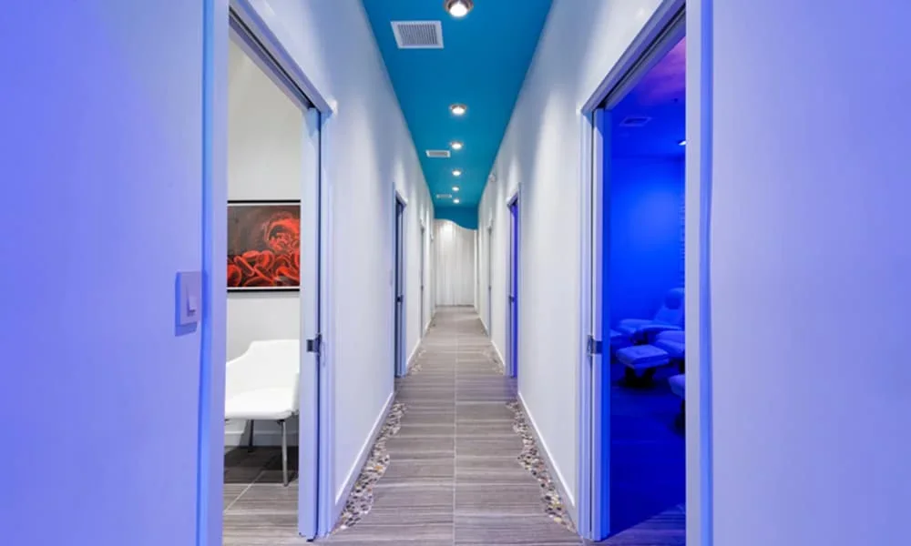Blue-lit interior hallway at the biostation East Delray Beach