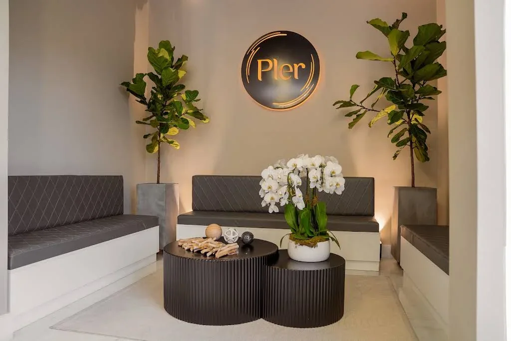Gray waiting benches, round tables and Pler wall sign.
