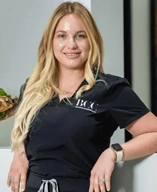 Julie Pernas standing in a black Brickell Cosmetic Center uniform.