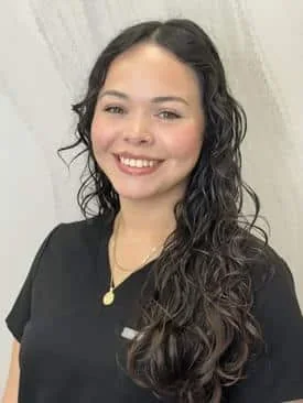 Lizzie Amaya wearing black scrubs against a gray background.
