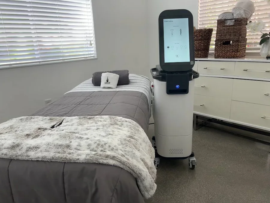 Empty room with a covered bed, treatment device, baskets and white cabinets.