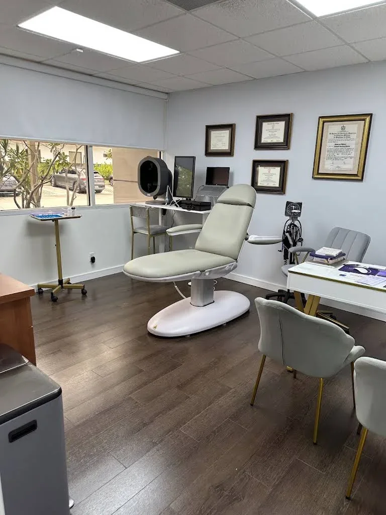 Empty reclining chair beside a window, framed certificates and idle equipment.