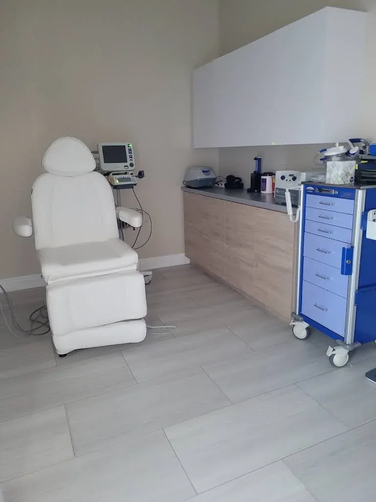 Empty white reclining chair beside cabinetry and idle equipment.