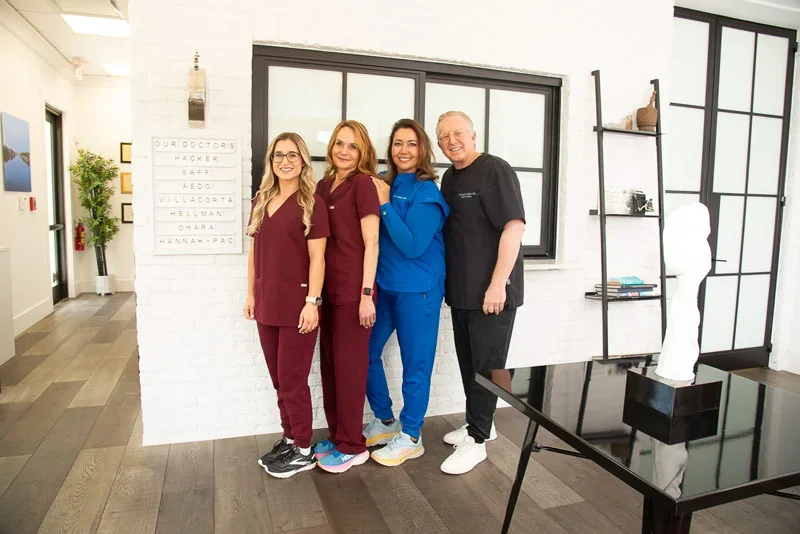 Hacker Dermatology team posed in the office reception area.