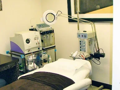 Empty room with a covered reclining bed, magnifying lamp and equipment.