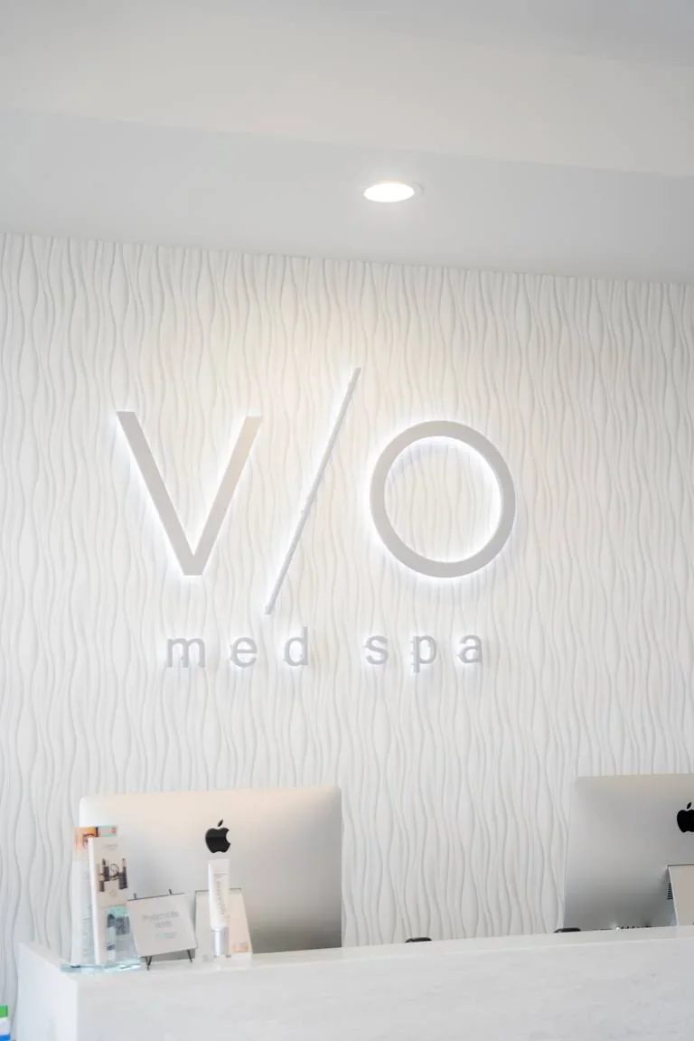 Illuminated VIO Med Spa signage above the Palm Beach Gardens reception desk.