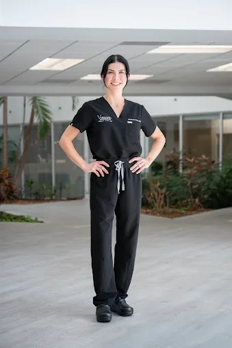 A practitioner in Vinas-branded medical scrubs in a covered courtyard.