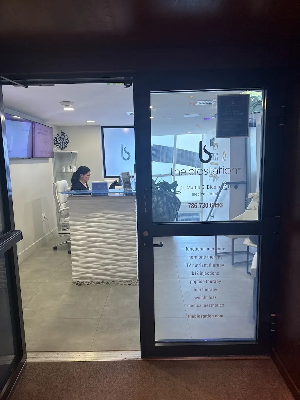 Glass entrance door with the biostation signage and reception desk inside.
