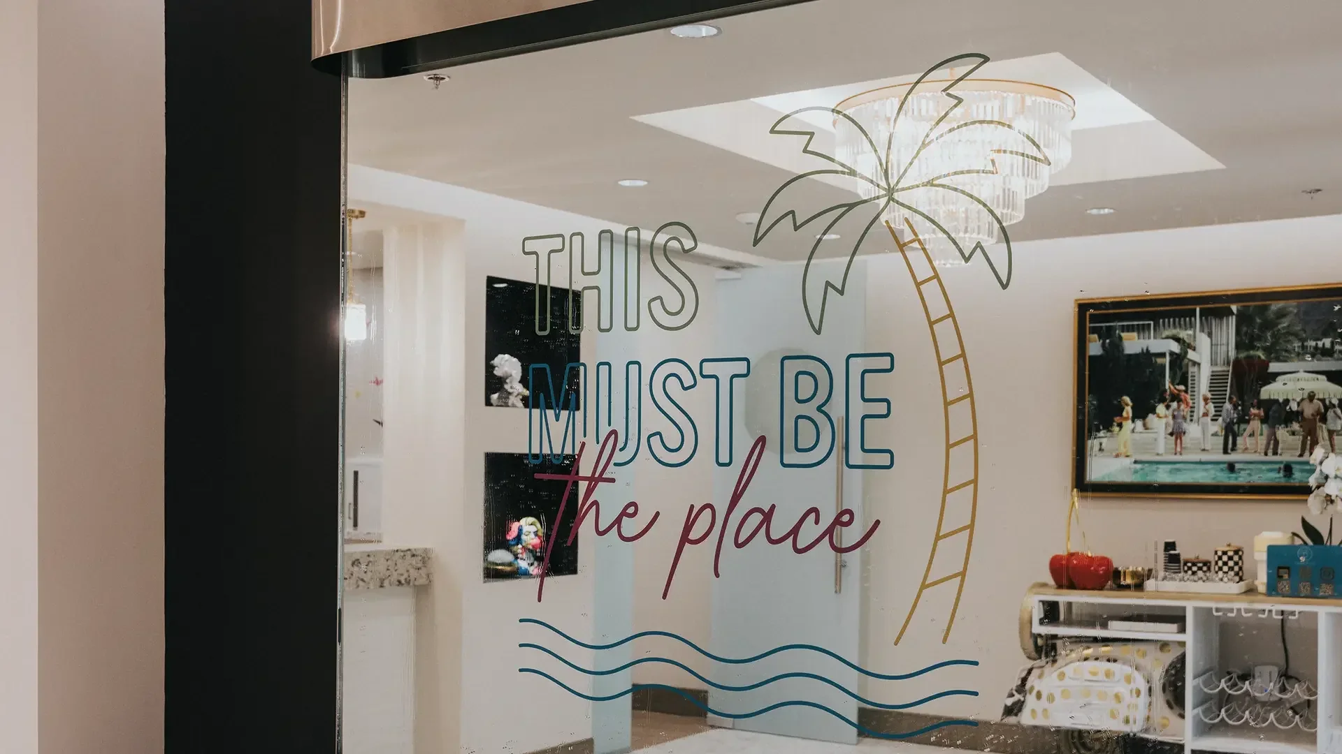 Palm-tree artwork and the words This must be the place on a lobby mirror.