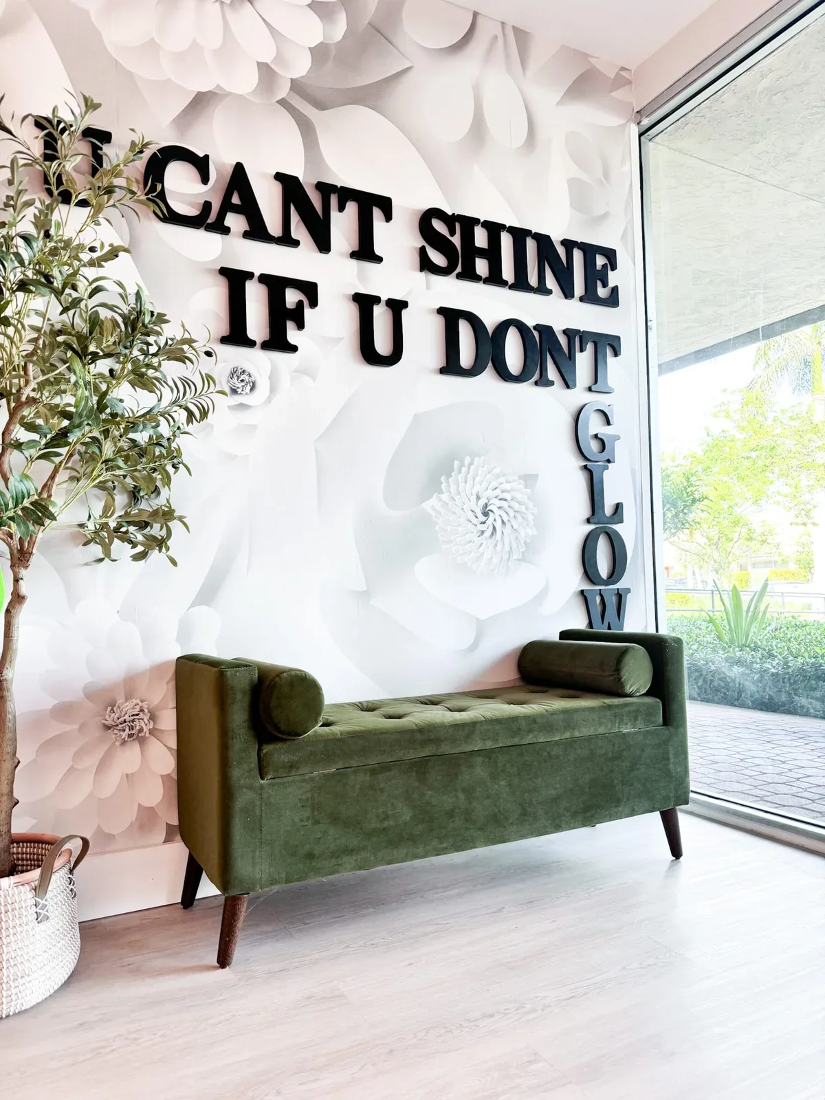 Green seating and floral wall in the glowU Med Spa waiting area
