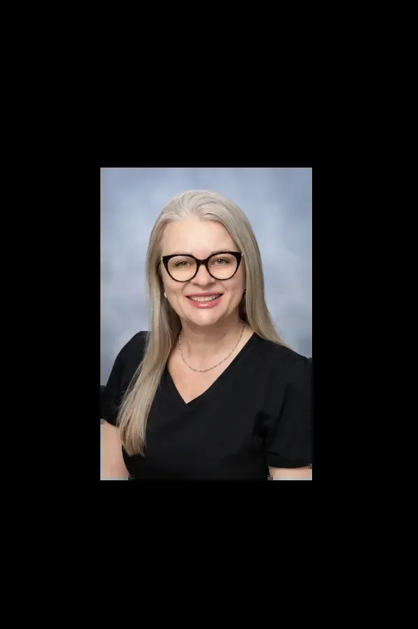 Irina Bresler wearing glasses and a black top in a studio portrait.