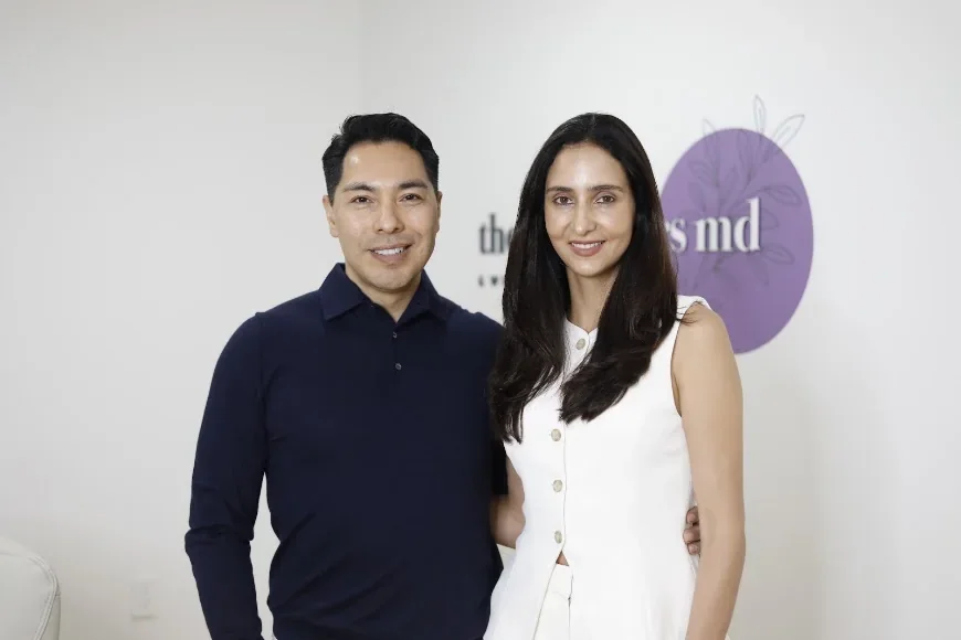 A posed team portrait in front of The Aesthetics MD & Wellness branding.