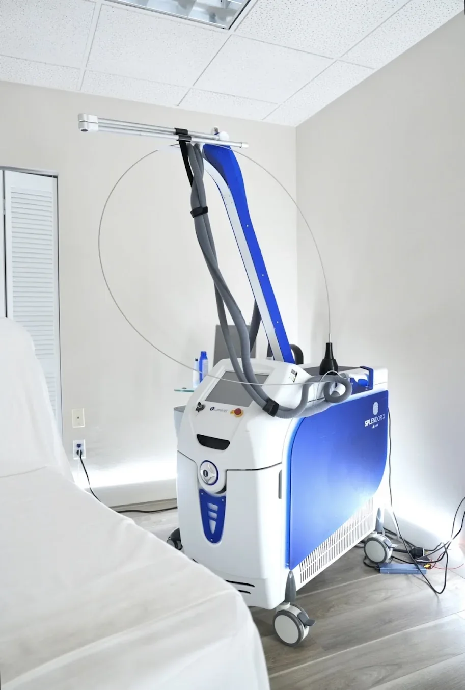 Blue and white freestanding equipment beside an empty covered chair.